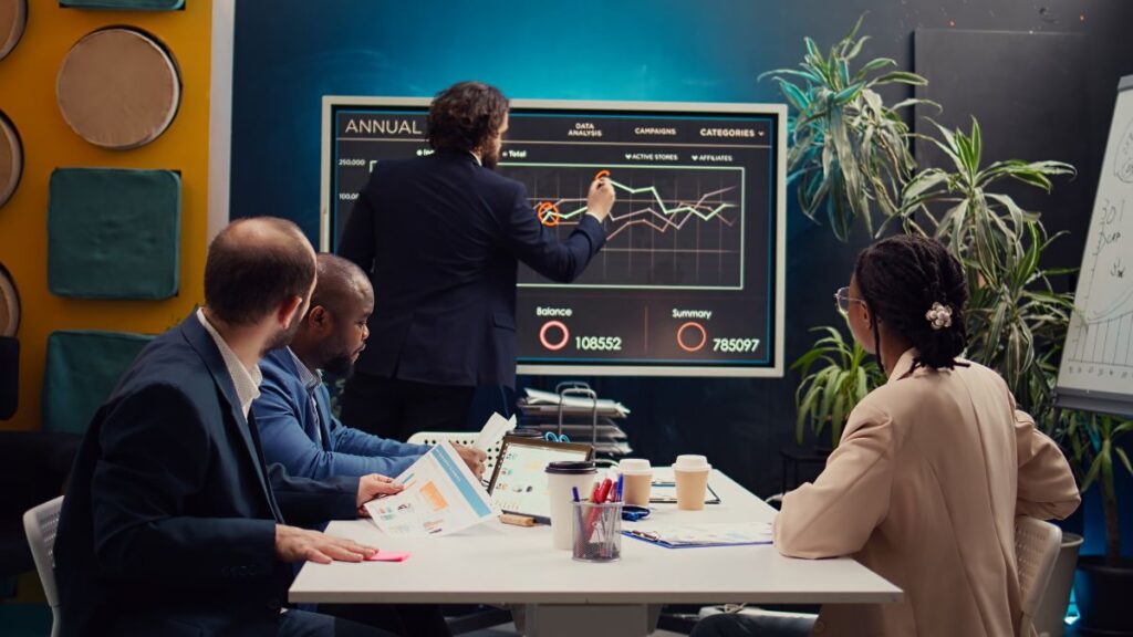 Business team reviewing sales recovery analytics and digital marketing performance strategy in a modern office meeting room
